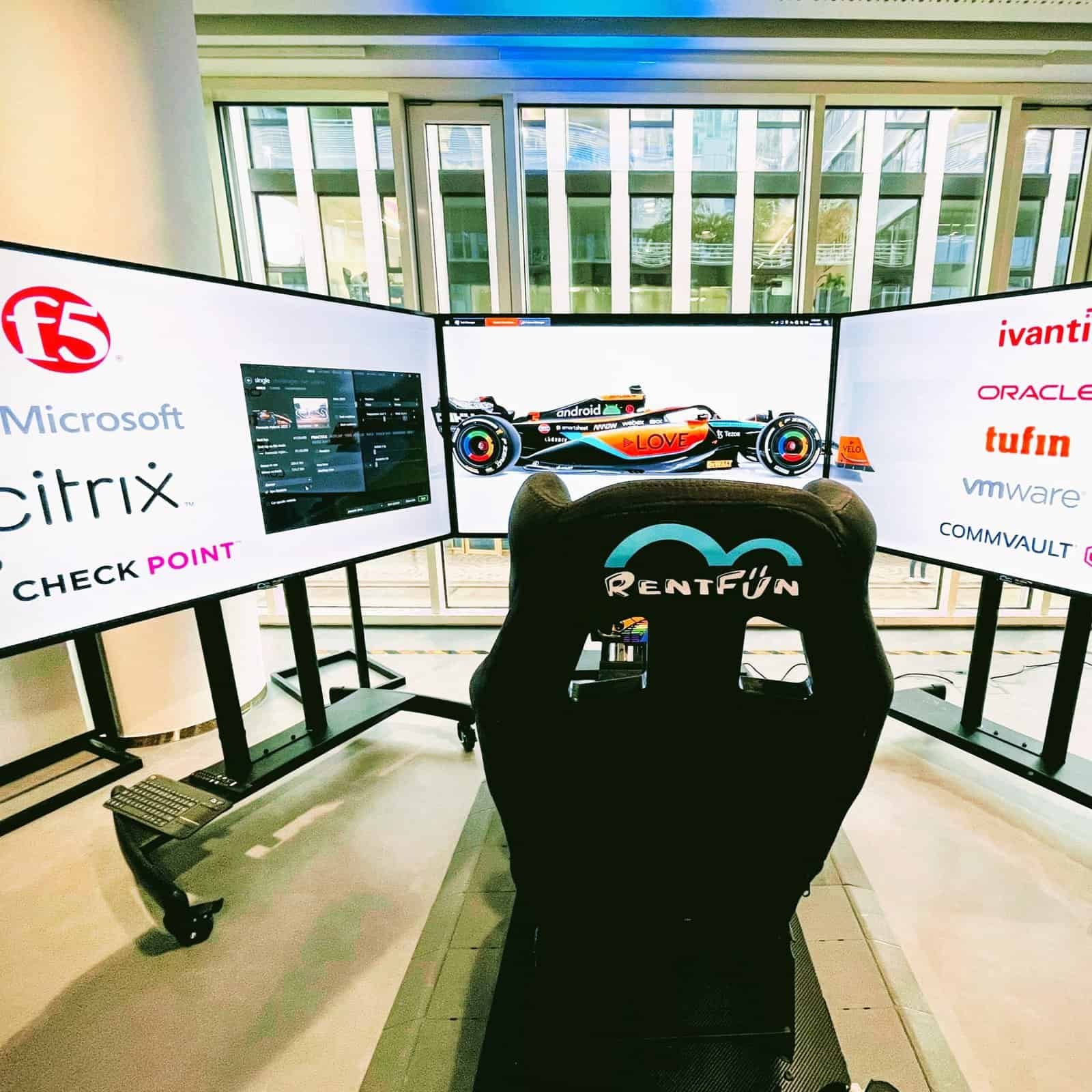 F1 motion racing simulator with 3 screens and branding.